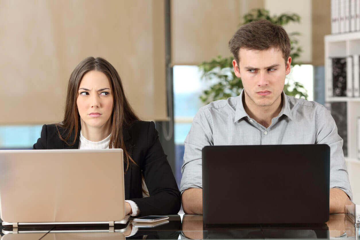 Two irritated co-workers sitting next to each other