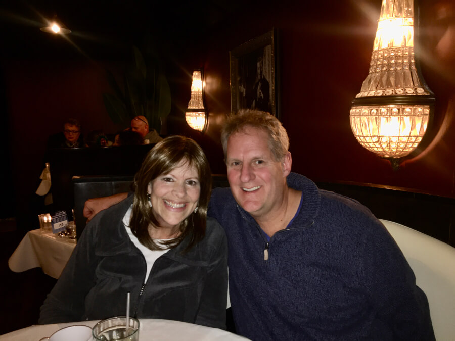 A woman and a man are sitting in a restaurant and posing for a photo