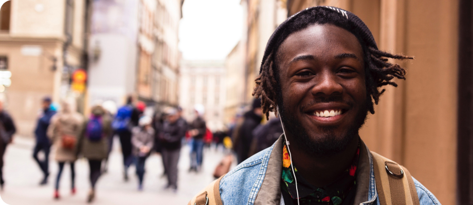 A smiling man in headphones, a crowd of people in the background