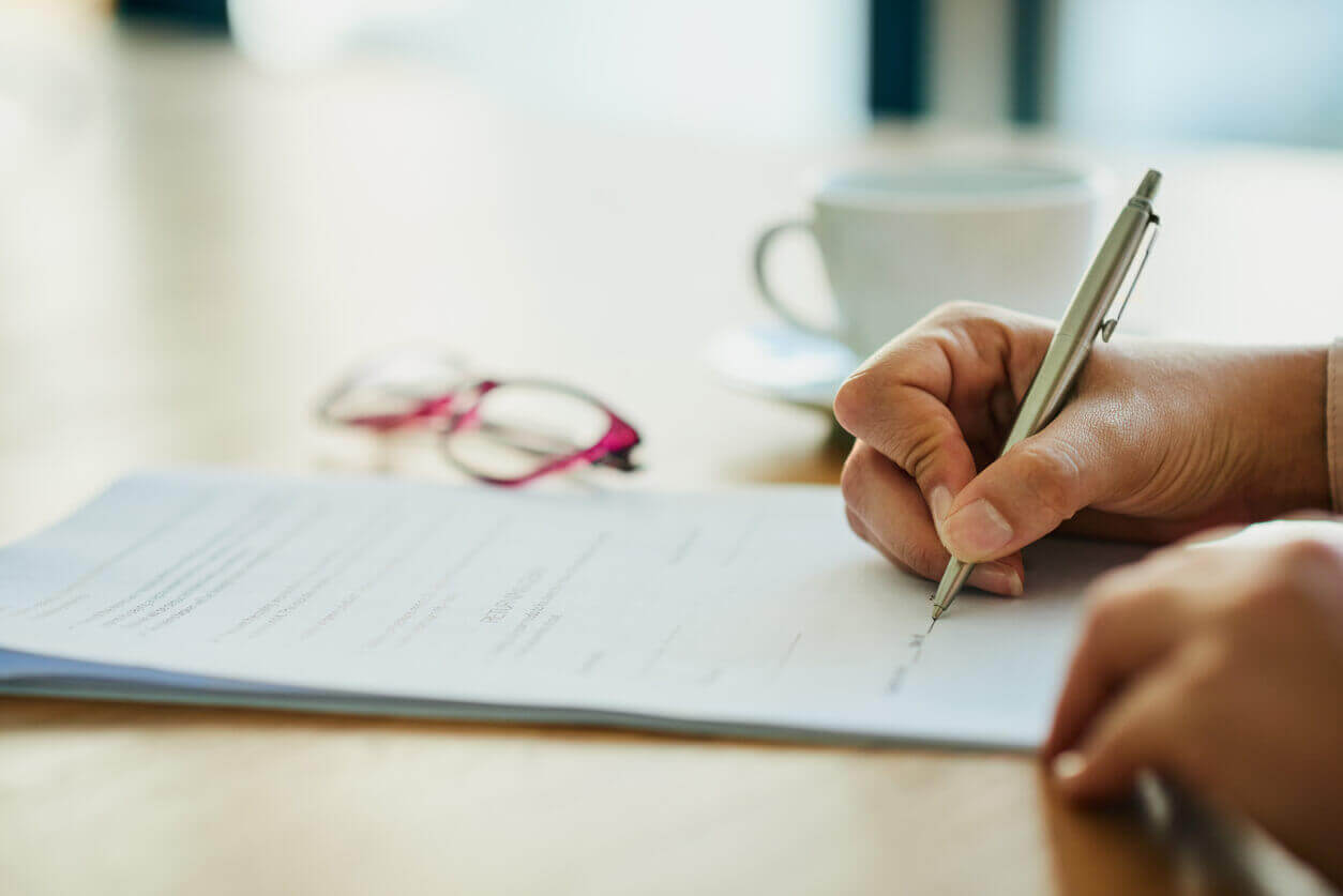 Close-up of hands signing a document