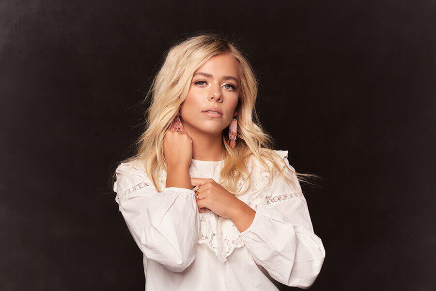 Anne Wilson posing for a photo in a white blouse