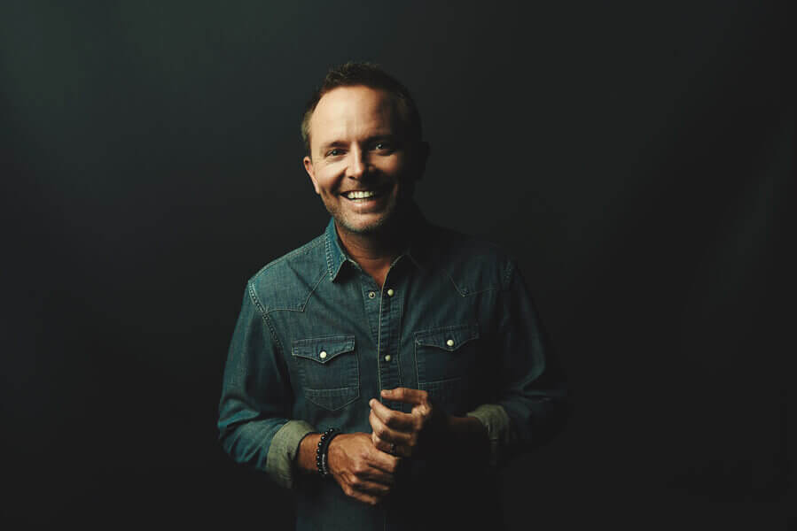 Chris Tomlin posing for a photo in a denim shirt