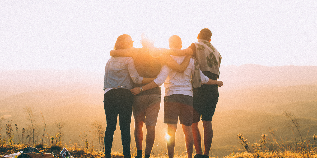 A group of friends with their arms around each other after completing a great hike