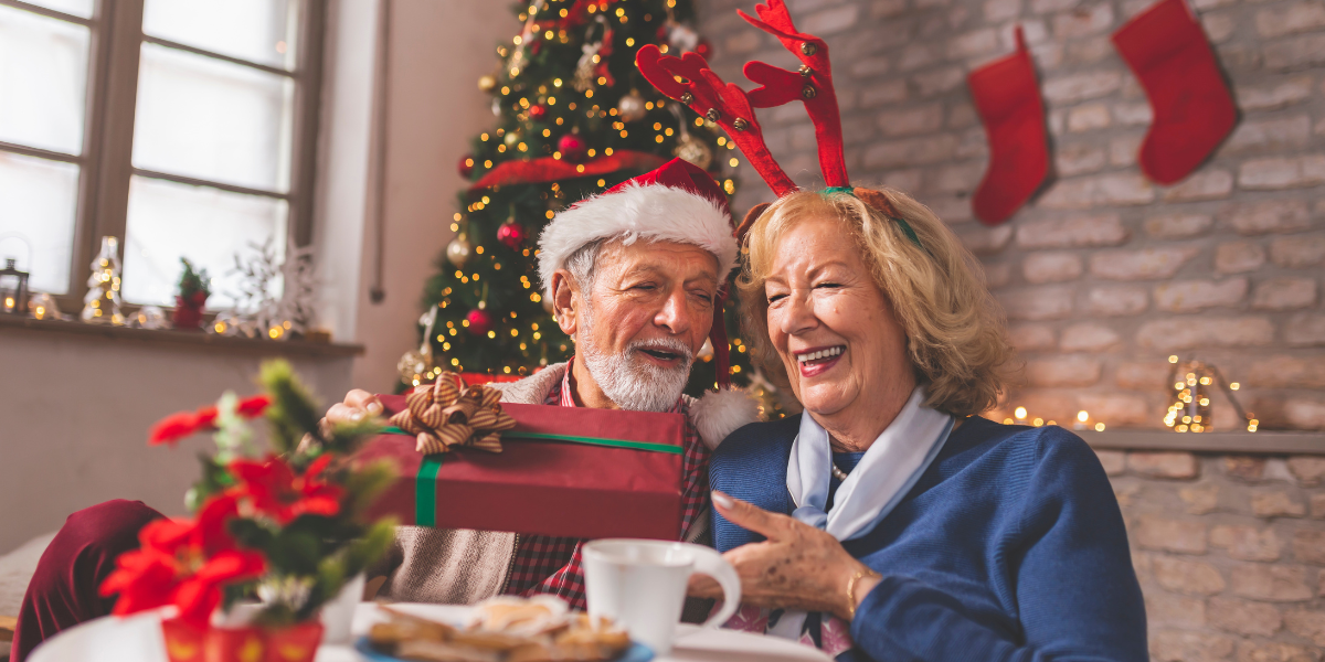 An elderly couple celebrating Christmas together happily