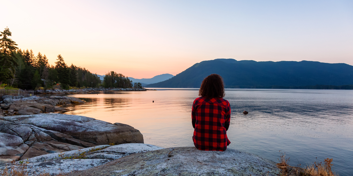 A person looking over a river during sunrise