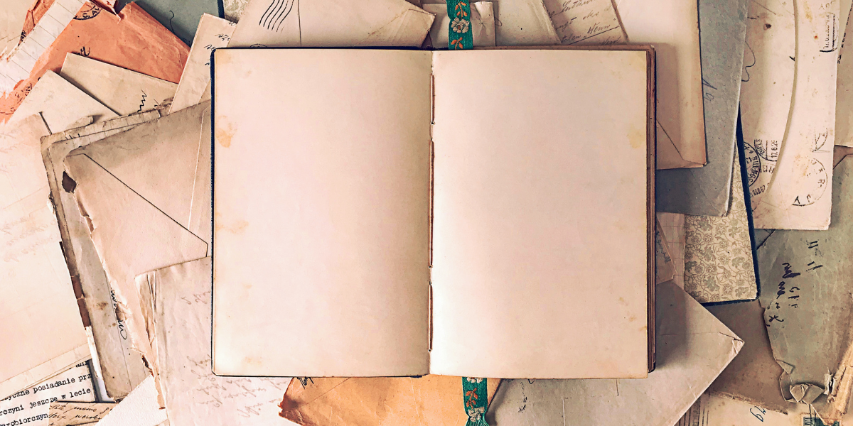 A blank journal laying on old papers from the past