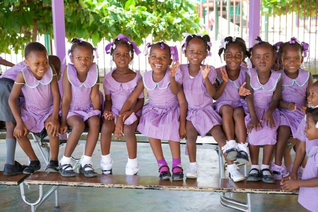 A group of adorable little girls dressed in matching purple dresses