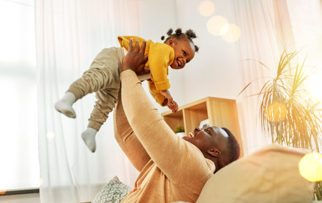 Mother holding happy baby in the air